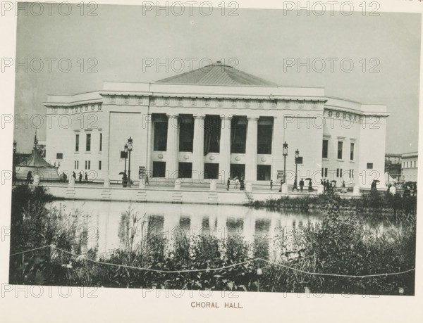 Choral Hall, View of a concert hall at the World's Columbian Exposition in Chicago in 1893, page, photomechanical print, number: 'Plate 42', photographer: Charles Dudley Arnold, Chicago, photographer: HD Higinbotham, cliché maker: anonymous, 1893, Charles Dudley Arnold, HD Higinbotham, photographer, cliché maker, North America, Illinois, paper, collotype, photoprint, height 134 mm x width 191 mm, world fair, world exhibition, concert hall, World's Columbian Exposition, A large classical building with a domed roof and a colonnaded front stands behind a low balustrade bordering a reflecting pool; the facade shows tall rectangular openings between fluted columns, decorative frieze elements along the roofline, and symmetrically placed windows on the side wings; people with umbrellas and hats walk along the terrace and steps in front of the building, and ornate street lamps rise near the entrance; vegetation and reeds grow along the near bank of the pool, and the water reflects the building...