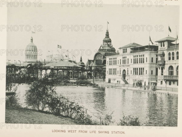 Looking west from Life Saving Station, View of the World's Columbian Exposition in Chicago in 1893, page, photomechanical print, number: 'Plate 66', photographer: Charles Dudley Arnold, Chicago, photographer: HD Higinbotham, cliché maker: anonymous, 1893, Charles Dudley Arnold, HD Higinbotham, photographer, cliché maker, North America, Illinois, paper, collotype, photoprint, height 133 mm x width 190 mm, world fair, world exhibition, World's Columbian Exposition, A riverside scene with a row of ornate buildings along a waterfront, including multi-story structures with arched windows, balconies, and rooftop flags; a domed pavilion and a larger tower with a cupola rise behind them, each topped with flags, and a covered walkway or bridge connects parts of the complex; people stand and walk along the paved waterfront promenade and small groups cluster near building entrances; trees and shrubs line the near bank and extend into the foreground, and reflections of the buildings and foliage ri...
