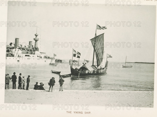 The Viking Ship, Viking ship in the water at the World's Columbian Exposition in Chicago in 1893, page, photomechanical print, number: 'Plate 70', photographer: Charles Dudley Arnold, Chicago, photographer: HD Higinbotham, cliché maker: anonymous, 1893, Charles Dudley Arnold, HD Higinbotham, photographer, cliché maker, North America, Illinois, paper, collotype, light printing, height 131 mm x width 191 mm, ships (in general), world fair, world exhibition, World's Columbian Exposition, A shoreline scene showing a sailboat with a large patterned sail and shields along its hull floating near the water, with flags flying from its mast and small rowboats nearby; a large steamship with funnels and deck structures is moored in the background to the left, and a group of people in period clothing stand and sit along the beach in the foreground watching the boats.