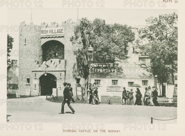 Donegal Castle, on the Midway, View of Ireland's contribution with a replica of Donegal Castle at the World's Columbian Exposition in Chicago in 1893, page, photomechanical print, number: 'Plate 95', photographer: Charles Dudley Arnold, Chicago, photographer: HD Higinbotham, clichémaker: anonymous, 1893, North America, Illinois, paper, collotype, photogravure, height 129 mm x width 190 mm, castle, world fair, world exhibition, World's Columbian Exposition, A stone castle entrance with battlements and a large arched doorway stands left of center, flanked by walls and a round tower, and a cottage-style building with a sloped roof is adjacent to it on the right, partially obscured by tall leafy trees; a decorative lamppost stands near the center foreground, several small freestanding signs or boards are placed near the castle entrance, and groups of people in early twentieth-century clothing and hats are walking or standing in front of the buildings, with one person striding across the op...