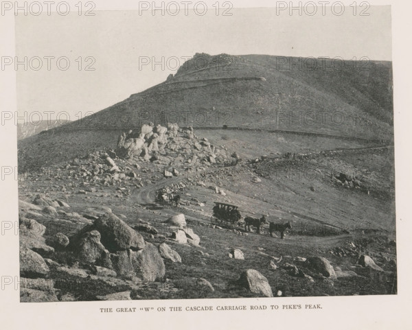 View of Pikes Peak and two carriages, The great W on the the cascade carriage road to Pike's Peak, page, photomechanical print, Colorado, cliché maker: New York Photo-Gravure Company, New York (city), c. 1888 - in or before 1893, New York Photo-Gravure Company, photographer, cliché maker, North America, paper, autotypie, height 154 mm x width 201 mm, four-wheeled vehicle drawn by more than three animals, mountain-top, peak, El Paso (Colorado), Pikes Peak (El Paso), A grayscale landscape showing a rocky hillside and ridge with scattered boulders and outcrops, a winding dirt road cutting across the slope, several horse-drawn wagons and teams traveling along the road, and a distant rocky peak and plateau under a pale sky.