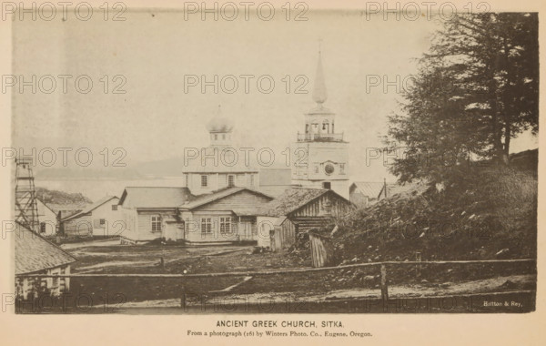 View of St. Michael's Orthodox Cathedral in Sitka, Ancient Greek church, Sitka, page, photomechanical print, inscription: 'From photograph (16) by Winter Photo Co., Eugene, Oregon.', photographer: Winter Photo Co., cliché maker: Britton & Rey, San Francisco, c. 1885 - in or before 1890, Winter Photo Co., Britton & Rey, photographer, cliché maker, North America, California, Alaska, paper, collotype, photoprint, height 109 mm x width 186 mm, city-view in general, 'veduta', church (exterior), A sepia-toned photograph shows a cluster of wooden buildings on uneven ground by a body of water, with a domed structure and a tower topped by a slender spire rising above surrounding roofs; the foreground contains a rough fence and patches of bare earth, while the right side of the image features a hillside with trees and dense foliage, and the left side shows additional small wooden structures and a simple wooden framework.