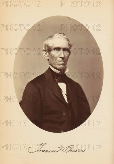 Francis Burns, Portrait of Francis Burns, photograph, page, photographer: Bendann Bros., c. 1866 - in or before 1871, paper, albumen print, height 148 mm x width 114 mm, Person, historical persons, An oval sepia-toned portrait of an older man shown from the waist up, wearing a dark coat with a high collar, a white shirt, and a bow tie, with short light-colored hair combed to the side, prominent ears, and a serious facial expression, set against a plain lighter background within a rectangular page.