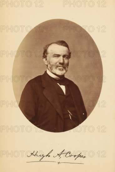 Portrait of Hugh A. Cooper, Hugh A. Cooper, photograph, page, photographer: Bendann Bros., c. 1866 - in or before 1871, paper, albumen print, height 137 mm x width 110 mm, Person, historical persons, An oval sepia-toned portrait of an older man shown from the chest up, seated and wearing a dark suit jacket, waistcoat, and a bow tie with a light shirt collar visible, his face framed by short hair and a trimmed beard and mustache, with a neutral background inside the oval and a light creamy border surrounding the portrait.