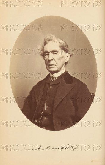 J. Meredith, Portrait of Jonathan Meredith, photograph, page, photographer: Bendann Bros., c. 1866 - in or before 1871, paper, albumen print, height 148 mm x width 114 mm, Person, Jonathan Meredith, historical persons, An oval-framed sepia photograph of an elderly man shown from the chest up wearing a dark suit jacket, vest, and a high-collared shirt with a patterned neckpiece, his hair light and tousled, his face long with deep-set eyes and prominent cheekbones, and the image set against a plain light background with a wide margin around the oval.