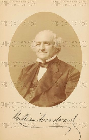 Portrait of William Woodward, William Woodward, photograph, page, photographer: Bendann Bros., c. 1866 - in or before 1871, paper, albumen print, height 147 mm x width 114 mm, Person, historical persons, An oval sepia-toned portrait of an older man with light wavy hair and sideburns, wearing a dark suit jacket, a vest, a high white collar, and a bow tie, centered on a light background with handwritten cursive text partially visible below the portrait.