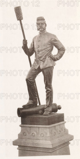 View of a detail of the civil war monument in Manchester, member of the artillery, page, photomechanical print, c. 1875 - in or before 1880, paper, collotype, photoprint, height 192 mm x width 94 mm, Print four pages before page 12., monument, statue, artillery range, firing range, shooting range, military training, A monochrome statue of a man standing on a sculpted pedestal is shown. He wears a uniform jacket with buttons and a cap, and has prominent facial hair. One hand rests on his hip while the other holds a long pole topped with a textured cylindrical object. One foot is placed forward on a cylindrical cannon-like object that lies horizontally on the pedestal. The pedestal has layered stonework with decorative rounded motifs and a stepped base. The statue appears rendered in a realistic style with visible folds in the clothing and detailed facial features.
