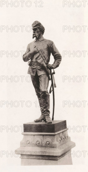 View of a detail of the civil war monument in Manchester, member of the cavalry, page, photomechanical print, c. 1875 - in or before 1880, paper, collotype, photoprint, height 190 mm x width 90 mm, Print after page 16., the soldier, the soldier's life, monument, statue, A monochrome statue of a standing man in a uniform with a cap, facial hair, and a sash across his chest is shown on a decorative stone pedestal; he stands with one hand resting on his hip near a sheathed sword and the other hand brought to his chest, wearing a belted tunic, trousers tucked into tall boots, and a strap crossing his torso, with the pedestal featuring rounded decorative elements and layered molding.