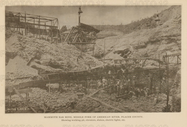 Mammoth Bar Mine, Middle Fork of American River, Placer County, View of Mammoth Bar Mine in Placer County, California, page, photomechanical print, inscription: 'Showing working pit, elevators, sluices, electric lights, etc.', maker: Britton & Rey, c. 1885 - in or before 1890, North America, paper, collotype, photoprint, height 112 mm x width 184 mm, mine, miner, A sepia-toned photograph shows a rugged excavation site with steep dirt and rock slopes and scattered rounded stones across the ground. Wooden scaffolding and elevated walkways cross the scene, with slanted beams and ladders connecting different levels. A tall pole topped with a bell-like structure rises above the central area, and another similar structure stands on a distant hillside. Workers wearing light clothing and hats are clustered along the lower platforms and among the rocks, with some figures on the elevated walkways. Crude wooden chutes and troughs run across the site, and piles of rocks and earth are heaped near t...