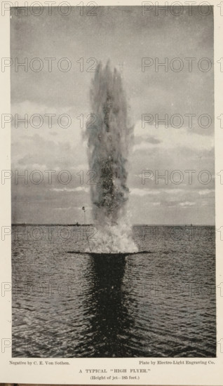 A typical 'high flyer', page, photomechanical print, photographer: CE von Sothen, cliché maker: Electro-Light Engraving Co., c. 1888 - in or before 1893, paper, autotypie, height 187 mm x width 108 mm, water course, projectiles, explosives, A tall, vertical column of water shooting upward from the surface of a body of water, with a dense plume at the base and a narrowing, misty top, reflected as a dark vertical shape on the rippling water below; the horizon line with a distant shoreline and small structures appears in the background beneath a sky filled with layered clouds.