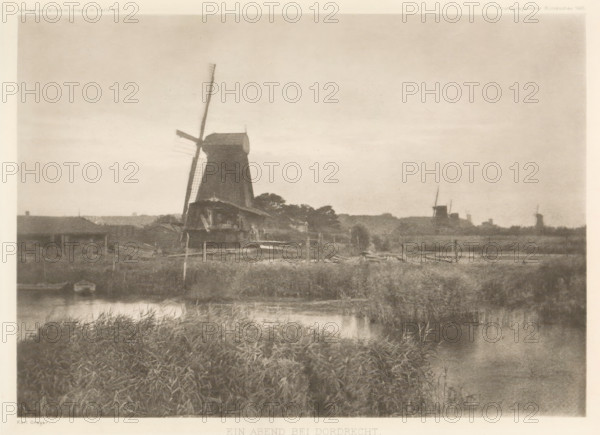 Landscape with windmills near Dordrecht, Ein Abend bei Dordrecht, page, photomechanical print, Sawmills on the Noordendijk in Dordrecht. From left to right: De Jager, De Windhond and De Duinen, all three paltrok mills. The mill furthest right is the sawmill De Nachtegaal., photographer: Karl Greger, Dordrecht, clichémaker: anonymous, publisher: Wilhelm Knapp Verlag, Halle an der Saale, c. 1896 - in or before 1901, Saxony-Anhalt, paper, photoaquatint, height 155 mm x width 219 mm, behind semi-transparent cover with advertising message., windmill in landscape, A sepia-toned landscape showing a large traditional windmill near the center with one of its sails angled diagonally, smaller buildings clustered around its base, grassy marshland and a body of water in the foreground reflecting the scene, and additional distant windmills and low structures along the horizon under a broad, lightly textured sky.