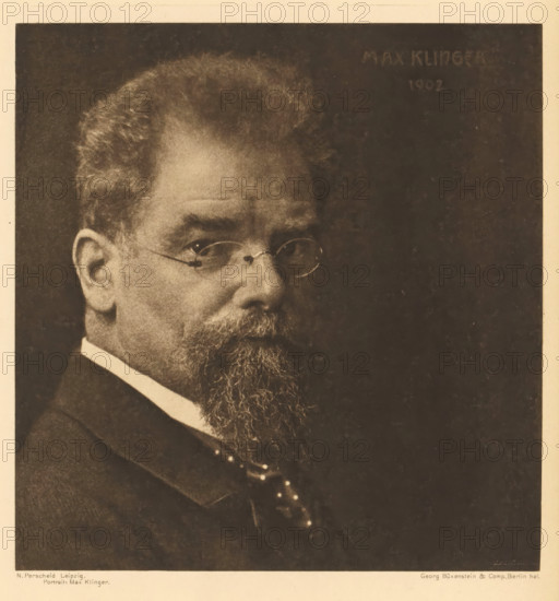 Portrait: Max Klinger, Portrait of Max Klinger, page, photomechanical print, photographer: Nicola Perscheid, cliché maker: Büxenstein & Comp., Georg, Berlin, 1902, 1902 - 1903, printer (person), paper, photoaquatint, height 165 mm x width 159 mm, Print ten of fourteen prints at the back of the book., Person, historical persons, A sepia-toned portrait of an older man shown from the shoulders up, featuring a full beard and mustache, round eyeglasses, a high-collared shirt, a suit jacket, and a patterned tie, with a dark plain background and a light margin around the image.