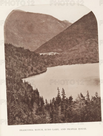 View of Franconia Notch, Echo Lake, and Profile House in the White Mountains, New Hampshire, Franconia Notch, and Profile House, page, photomechanical print, White Mountains, c. 1874 - in or before 1879, North America, paper, collotype, photoprint, height 163 mm, width 127 mm, Print for chapter 12., lake, hotel, hostelry, inn, mountains, A sepia-toned photograph showing a large lake bordered by densely forested hills and mountains, with tall conifer trees in the foreground and tree-covered slopes rising steeply on either side, a light-colored multi-wing building tucked near the far shore, and layered mountain ridges fading into the background under a pale sky.