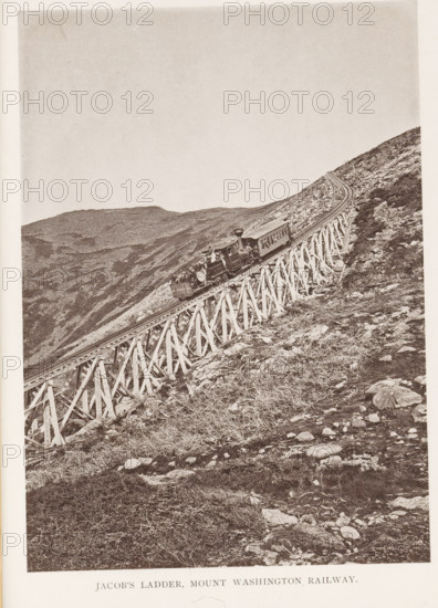 Jacob's Ladder, Mount Washington Railway, View of a train on a railway bridge on Mount Washington in the White Mountains, New Hampshire, page, photomechanical print, Washington, Mount, c. 1874 - in or before 1879, North America, Coos, paper, collotype, photogravure, height 178 mm, width 128 mm, Print for chapter 9., railway, train, mountains, bridge, A sepia-toned photograph of a steep hillside with a wooden trestle carrying a narrow railway track diagonally across the image from lower left to upper right, a small steam locomotive with an attached passenger car and an open-front car visible on the trestle, rocky terrain and sparse low vegetation on the slope surrounding the structure, and distant rounded mountain ridges in the background under a pale sky.
