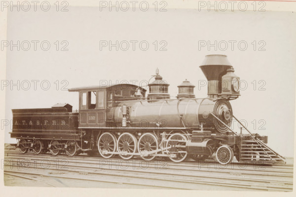 American freight steam locomotive, photograph, page, number: '627', United States of America, c. 1871 - in or before 1881, photographer, North America, paper, albumen print, height 123 mm x width 198 mm, Photo on page 104., steam locomotive, A sepia-toned side view of a steam locomotive and its tender resting on railroad tracks, showing the engine's large driving wheels with visible spokes, connecting rods, and mechanical linkages, a cylindrical boiler with domed steam domes and a bell mounted near the cab, a square cab with window openings, a tall tapered smokestack and a large rectangular headlight box at the front, and the tender behind the cab with a sloped top and visible wheelsets.