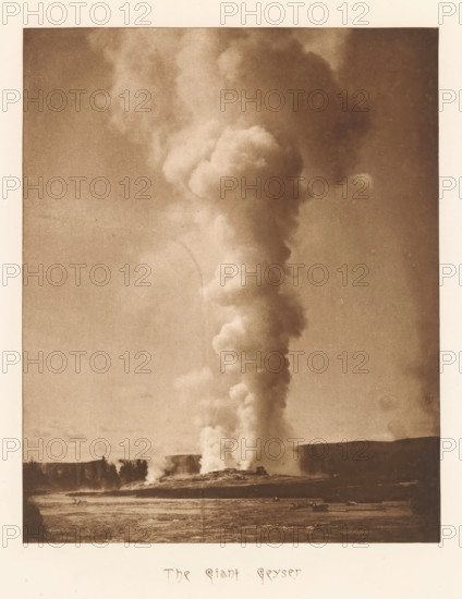 The Giant Geyser, page, photomechanical print, photographer: Frank Jay Haynes, Yellowstone National Park, cliché maker: The Photo-gravure Co., New York (city), c. 1882 - in or before 1887, North America, paper, photoaquatint, height 207 mm x width 165 mm, hot spring, geyser, Giant Geyser, A tall column of light-colored steam rises from a ground opening and extends upward through the sky, forming billowing rounded clouds that widen and diffuse near the top; the steam contrasts with a darker sky and stands above a flat landscape with a tree-lined horizon, scattered low vegetation, and a foreground area of textured ground.