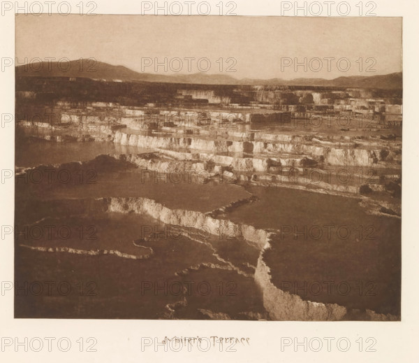 Jupiter's Terrace, page, photomechanical print, photographer: Frank Jay Haynes, Yellowstone National Park, cliché maker: The Photo-gravure Co., New York (city), c. 1882 - in or before 1887, Frank Jay Haynes, The Photo-gravure Co., photographer, cliché maker, North America, paper, photoaquatint, height 165 mm x width 213 mm, hot spring, geyser, A wide sepia-toned landscape image showing layered, stepped terraces with lighter horizontal edges and darker flat surfaces, stretching toward a distant horizon of low rounded hills beneath a pale sky, with irregular channels and textured surfaces visible across the terraces and a pale border surrounding the image.