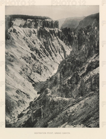 Inspiration point, Grand Canyon, page, photomechanical print, photographer: Frank Jay Haynes, Yellowstone National Park, cliché maker: The Photo-gravure Co., New York (city), c. 1886 - in or before 1891, North America, paper, collotype, photoprint, height 215 mm x width 165 mm, ravine, chasm, abyss, canyon, A black and white photograph of a steep rocky canyon with jagged cliffs and layered rock faces; the left side shows a sloping pale rock surface with scattered small trees and dark vertical streaks, while the right side features towering dark crags and rugged cliff edges with sparse vegetation; a narrow river or watercourse runs at the canyon floor winding between the rock walls; the distant background includes a hazy ridge line and a flat-topped plateau beneath a light sky; the image has a wide pale border around it.