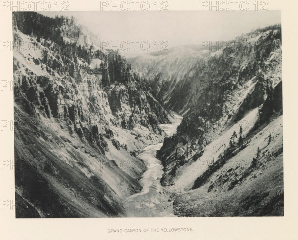 Grand canyon of the Yellowstone, page, photomechanical print, photographer: Frank Jay Haynes, Yellowstone National Park, cliché maker: The Photo-gravure Co., New York (city), c. 1886 - in or before 1891, North America, paper, collotype, photoprint, height 165 mm x width 215 mm, ravine, chasm, abyss, canyon, Grand Canyon (Yellowstone National Park), A wide grayscale photograph of a steep rocky canyon with rugged cliffs on both sides and a river winding through the canyon floor. The cliff faces show layered rock formations and scattered trees clinging to slopes and ledges, with denser stands of taller trees near the upper edges. The river appears lighter in tone against the darker canyon walls and flows from the distant background toward the foreground, with visible rapids and curving channels. The slopes beside the river vary from steep rocky ridges to smoother talus-covered areas dotted with small trees and shrubs. The upper background fades into a hazy sky above the distant ridgelines...