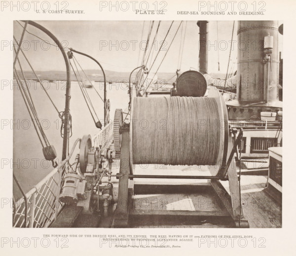Dredge reel on the deck of the George S. Blake, page, photomechanical print, inscription: 'The forward side of the dredge reel and its engine. The reel having on it 2700 fathoms of the steel rope recommended by professor Alexander Agassiz.', name: 'Heliotype Printing Co., 220 Devonshire St., Boston.', number: 'Plate 32.', United States of America, printer (person): Heliotype Printing Company, Boston (Massachusetts), c. 1870 - in or before 1880, printer (person), North America, Massachusetts, paper, collotype, photoprint, height 168 mm x width 218 mm, ships (in general), dredge, dredging machine, A sepia-toned photograph showing a ship's deck with a large horizontal reel of rope mounted on a metal frame in the center foreground, coiled rope visible on the drum; machinery with gears and pipes sits beside the reel toward the left, and a railing with netting runs along the left edge; rigging lines, pulleys, and curved metal stanchions extend upward and diagonally across the scene; toward t...