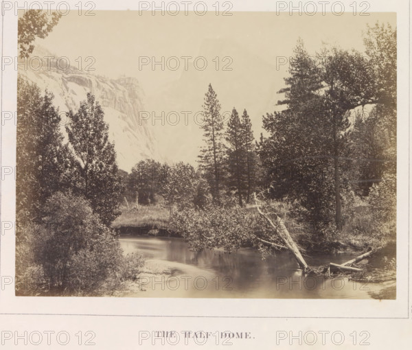 View of the Half Dome in the Yosemite Valley, The Half Dome, photograph, page, number: 'XIV.', photographer: Carleton E. Watkins, Yosemite Valley, c. 1860 - in or before 1868, North America, California, paper, albumen print, height 155 mm x width 206 mm, river, mountains, rock-formations, dale, valley, Half Dome, A sepia-toned landscape photograph showing a river in the foreground with smooth reflective water, a fallen pale tree trunk leaning into the river from the right bank, dense shrubs and undergrowth along the water’s edges, and a variety of tall coniferous and broadleaf trees rising behind the river; in the midground the treeline opens to reveal steep rocky cliffs on the left with sheer exposed rock faces, while a hazy lighter area occupies the upper center background and the scene is framed by more trees along the right and left margins.