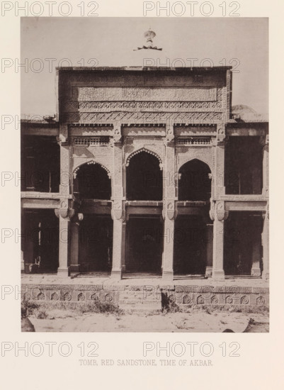 View of a tomb in India from the time of Emperor Akbar, India, page, photomechanical print, title: 'TOMB, RED SANDSTONE, TIME OF AKBAR.', number: 'VII.', maker: Heliotype Printing Company, Boston (Massachusetts), c. 1875 - in or before 1885, photographer, North America, Massachusetts, paper, photoaquatint, height 222 mm x width 175 mm, grave, tomb, A sepia-toned photograph of a building façade showing an ornate upper panel with carved geometric and floral patterns and a cornice, below which are three arched openings framed by decorative columns and carved brackets, a pair of engaged pillars flanking each arch, dark recessed interior spaces visible through the arches, a patterned plinth running along the base with circular medallion motifs, a short central flight of stone steps leading up to the entrance level, patches of vegetation and rough ground in front of the structure, and a light border surrounding the image.