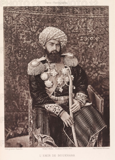 l'Emir de Bukhara, Portrait of the Emir of Bukhara, page, photomechanical print, photographer: Paul Nadar, Bukhara, cliché maker: Dujardin, France, printer (person): Chardon-Wittmann, 1890-10, Paul Nadar, Dujardin, Chardon-Wittmann, photographer, cliché maker, printer (person), Emirate of Bukhara, paper, photoaquatint, height 176 mm x width 132 mm, ruler, sovereign, head-gear: turban, A seated man wearing a patterned turban and a full beard looks toward the camera while dressed in a richly decorated uniform with ornate shoulder epaulettes, embroidered cuffs, and a sash adorned with multiple large star-shaped medals; he holds a long curved sword with one hand resting on its hilt and the other on his knee, and a patterned textile backdrop fills the space behind him.