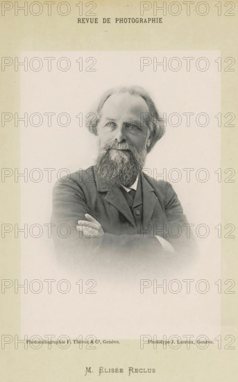 M. Élisée Reclus, Portrait of Élisée Reclus, page, photomechanical print, maker: Jean Lacroix, maker: F. Thévoz & Cie., c. 1887 - in or before 1892, paper, collotype, photoprint, height 145 mm x width 100 mm, Person, Élisée Reclus, historical persons (portraits and scenes from the life), A faded portrait photograph of a bearded man shown from the chest up with his arms crossed, framed by a pale rectangular border on a cream-colored page. The man has a full beard and mustache, receding hair with longer hair at the sides, and light-colored eyes. He wears a dark suit jacket over a vest and a light-colored shirt with a visible collar. The background inside the framed area is plain and light, while the surrounding page shows a textured, slightly aged paper tone. There is printed text above and below the portrait on the page.
