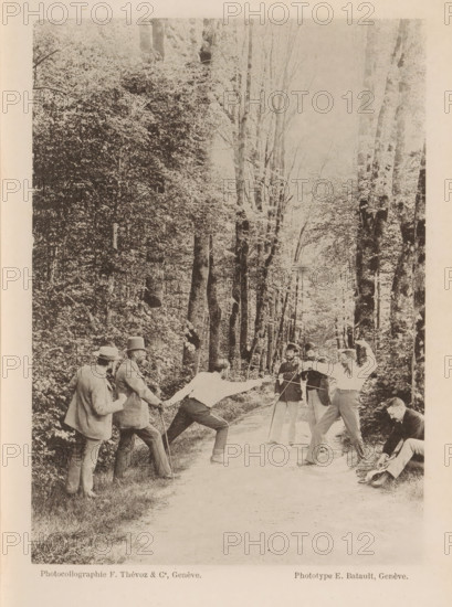 A group of unknown men, two of whom are fencing on a path through the forest, Action, page, photomechanical print, maker: F. Thévoz & Co., maker: E. Batault, c. 1888 - in or before 1893, paper, collotype, photoprint, height 162 mm x width 116 mm, lighting, lamps, fencing (sport), edifice, eg: public building, department store - AA - civic architecture: inside, A sepia-toned photograph shows a tree-lined dirt path with tall trees and dense foliage on both sides, creating a canopy overhead. On the path a group of men are engaged in a fencing duel, two men facing each other in lunging stances with arms extended and foils raised, while several other men stand nearby watching; some wear suits and hats, one holds a cane, and another is seated at the path edge adjusting something near his feet. The scene captures varied postures and focused expressions among the participants against the backdrop of the wooded avenue.