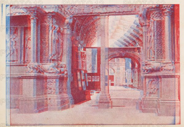 View of an entrance to a room of the Musée archeologique du trocadéro, Musée archeologique du trocadéro, Paris, page, photomechanical print, anaglyph, workshop stamp: 'No 7887, post, tenebras, spero, lucem', cliché maker: Bonnamy, maker: Comptoir Suisse de Photographie, c. 1889 - in or before 1894, paper, two-color autotype, Two-color autotype in blue and red., height 124 mm x width 179 mm, exhibition, art, A large architectural interior rendered in overlapping red and blue tones shows a colonnaded corridor with ornate carved pillars and decorative reliefs, reclining sculpted figures on plinths, arched vaulting overhead, a series of doorways and arches receding into the distance, framed rectangular panels or easels leaning against a column, stone floors and benches, and an overall layered, duotone printed appearance.