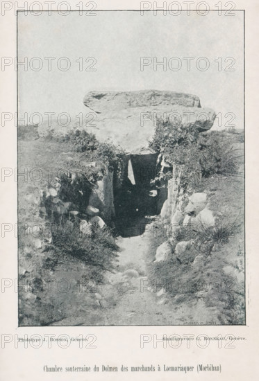 Chambre souterraine du Dolmen des marchands à Locmariaquer (Morbihan), View of a dolmen, page, photomechanical print, maker: J. Bosson, maker: G. Bonneau, c. 1890 - in or before 1895, paper, autotypie, height 156 mm x width 112 mm, megalithic chambered tomb, dolmen, Locmariaquer, A black and white photograph of a stone structure set into a grassy hillside, with a large flat capstone resting atop a rectangular opening framed by vertical stone slabs and surrounded by shrubs and low vegetation, a dirt path leading up to the dark entrance, scattered rocks and tufts of grass along the sides, and an expansive pale sky above.