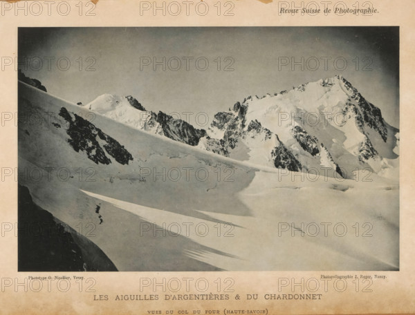 View of the Aiguille d'Argentières and the Aiguille de Chardonnet in the French Alps, Les Aiguilles d'Argentières & du Chardonnet, page, photomechanical print, inscription: 'vues du col du four (Haute-Savoie)', maker: O. Nicollier, maker: Jules Royer, c. 1891 - in or before 1896, paper, collotype, photoprint, height 111 mm x width 172 mm, mountain range, snow peaks, Argentière glacier, Aiguille du Chardonnet, A black and white photograph of a snowy mountain scene framed by a pale border, showing a sweeping snowfield in the foreground with long diagonal shadows, a steep snow-covered slope cutting across the midground, and jagged rocky peaks capped with snow rising in the background under a clear sky.