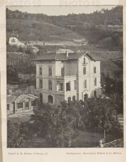 View of a villa in a mountainous landscape, probably in Switzerland, page, photomechanical print, photographer: M. Röbeke, Switzerland (possibly), cliché maker: Meisenbach, Riffarth & Cie., Munich, c. 1893 - in or before 1898, Bavaria, paper, autotypie, height 152 mm x width 125 mm, villa, low hill country, A multi-story pale building with arched ground-floor openings and rectangular windows on upper levels stands in front of a hillside covered with rows of vegetation and scattered small structures; the building has decorative balcony railings, a pitched roof with chimneys, and an ornamental gable above one facade, while leafy trees fill the foreground and a smaller structure with large windows and a pitched roof sits to the left.