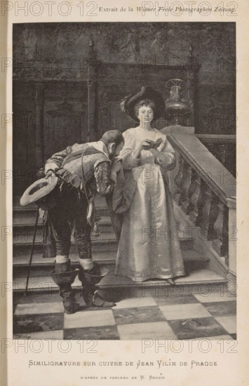 Reproduction of a painting by Václav Brožík, reproduction, page, photomechanical print, inscription: 'Extrait de la Wiener Freie Photographen Zeitung.', maker: Jean Vilim, after painting by Václav Brožík, c. 1894 - in or before 1899, paper, autotypie, height 169 mm x width 119 mm, adult woman, adult man, staircase, A grayscale image of two people on a staircase inside a building with a patterned floor and ornate wooden wall panels; a woman stands on the steps wearing a long, flowing dress and a wide-brimmed hat with a feather, holding a small open book and looking slightly downward, while a man in period clothing bends toward her with one hand raised near his face and the other holding a hat, wearing boots and a cane at his side; a carved balustrade runs along the right side of the stairs and a decorative urn or lamp sits on the newel behind the woman, with shadows and textures visible on the wall panels and steps.