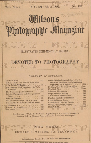 Wilson's photographic magazine, magazine, name: 'D. Davis', publisher: Edward Livingston Wilson, New York (city), 1892-11-05, Edward Livingston Wilson, publisher, North America, paper, printing, wood engraving, autotype, albumen print, height 257 mm x width 176 mm x thickness 4 mm, A vertically oriented aged paper cover with a pale tan background and a thin border, featuring a large ornate title in decorative blackletter type near the top center and a smaller decorative line beneath it, a centered bold heading further down, and two narrow columns of smaller printed entries separated by a vertical rule in the middle section; the top margin includes a few small printed lines and a faint pencil inscription at the upper right, and the bottom portion shows a centered line of larger text followed by another horizontal rule and additional smaller printed lines toward the lower edge.