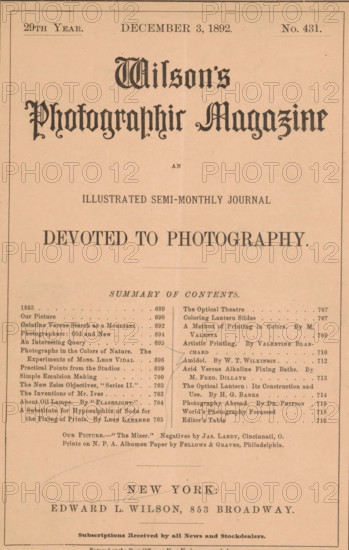 Wilson's photographic magazine, magazine, publisher: Edward Livingston Wilson, New York (city), 1892-12-03, Edward Livingston Wilson, publisher, North America, paper, printing, wood engraving, autotype, albumen print, height 256 mm x width 175 mm x thickness 4 mm, The image shows a portrait-oriented page with a light tan background and a thin dark border around the edges; the top third features a large ornate black title in a decorative script centered near the top, with smaller lines of dark text below it, and a small gap before a bold centered declaration in uppercase letters; the middle contains a densely printed two-column list of short entries with dot leaders and occasional darker marks and underlines between the columns, and faint pencil or pen curved lines crossing parts of the left and center; the lower area shows a larger centered place name in uppercase with a decorative horizontal oval-like pencil mark overlapping it, followed by a line of smaller dark text and a narrow rul...
