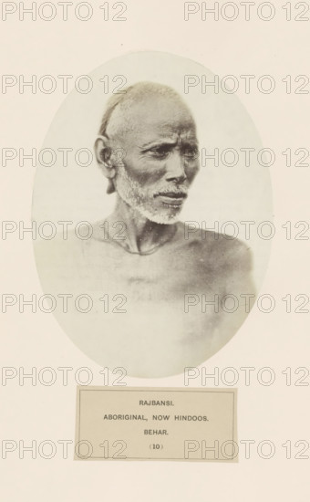 Portrait of an unknown man from the Rajbanshi community of Bihar in eastern India, photograph, page, number: '(10)', inscription: 'RAJBANSI., ABORIGINAL, NOW HINDOOS., BEHAR.', Bihar, c. 1858 - in or before 1868, photographer, North India, paper, albumen print, height 175 mm x width 130 mm, human races, peoples, nationalities, An oval-framed sepia portrait of an older man shown from the shoulders up against a light background, his head turned slightly to the side, with short cropped hair and a trimmed white beard and mustache, deep-set eyes and furrowed brow, prominent cheekbones and visible facial lines, bare upper torso and neck with a thin necklace, printed on a light page with a rectangular caption block below.