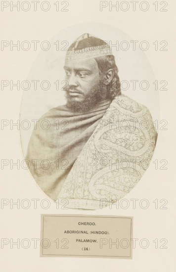 Portrait of an unknown man from the Chero community from Palamu in Jharkhand, India, photograph, page, number: '(14)', inscription: 'CHEROO., ABORIGINAL (HINDOO)., PALAMOW.', Palamu, c. 1858 - in or before 1868, photographer, Jharkhand, paper, albumen print, height 177 mm x width 130 mm, human races, peoples, nationalities, A sepia-toned oval portrait of a dark-skinned man shown from the shoulders up, wearing a patterned cap and a shawl draped over his shoulders; his face is turned slightly to his left with a calm expression, a full beard and mustache, and short curly hair visible at the sides, while the shawl on his right shoulder displays an intricate swirling floral pattern and the background around the oval is plain.