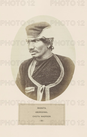 Portrait of an unknown man from the Bhogta community of Chota Nagpur in eastern India, photograph, page, number: '(23)', inscription: 'BHOGTA., ABORIGINAL., CHOTA NAGPOOR.', photographer: Benjamin Simpson (possibly), Chota Nagpur, c. 1858 - in or before 1868, Jharkhand, paper, albumen print, height 160 mm x width 120 mm, human races, peoples, nationalities, head-gear: cap, Oval-framed sepia portrait of a man shown from the chest upward, wearing a rounded cap and a dark garment with a lighter decorative trim forming a looped shape and tied at the front, the man looking slightly to his left with a mustache and short curly hair visible at the ear, the image set against a pale background with a rectangular panel below the portrait.