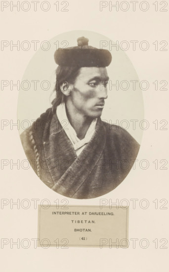Portrait of an unknown man from Bhutan in Darjeeling, West Bengal, photograph, page, number: '(41)', inscription: 'INTERPRETER AT DARJEELING., TIBETAN., BHOTAN.', photographer: Benjamin Simpson (possibly), Darjiling, c. 1858 - in or before 1868, Bengal, Northeast India, paper, albumen print, height 160 mm x width 120 mm, head-gear: hat, human races, peoples, nationalities, A sepia photographic portrait shows a person in an oval frame facing right with a composed expression and a narrow face. The person wears a rounded hat with a small rounded adornment on top and has long hair pulled back, one section braided and resting over a shoulder. They are dressed in layered garments with a visible collar and a textured outer robe that crosses at the front. The background inside the oval is plain and light, and the oval image is set on a larger pale background with a rectangular label area below.