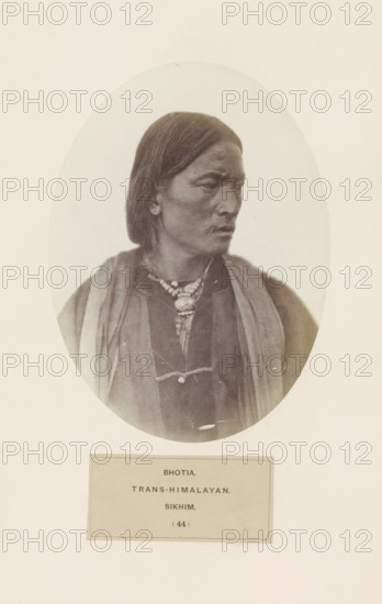 Portrait of an unknown man from the Bhutia community of Sikkim, photograph, page, number: '(44)', inscription: 'BHOTIA., TRANS-HIMALAYAN., SIKHIM.', photographer: Benjamin Simpson (possibly), Sikkim, c. 1858 - in or before 1868, paper, albumen print, height 175 mm x width 129 mm, human races, peoples, nationalities, An oval-framed sepia photograph shows a three-quarter portrait of a person with straight dark hair falling to about shoulder length, a serious facial expression, and gaze turned to the side; the person wears layered garments including a dark tunic and lighter shawl-like drapes over the shoulders, and a beaded necklace with a pendant hanging at the center, all set against a light background with a rectangular mat visible below the oval.