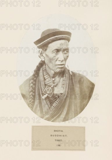 Portrait of an unknown man from the Bhutia community of Tibet, photograph, page, inscription: 'BHOTIA., BUDDHIST., TIBET.', number: '(54)', photographer: Benjamin Simpson (possibly), Tibet, c. 1858 - in or before 1868, paper, albumen print, height 175 mm x width 130 mm, Hinduism, Buddhism, Jainism, human races, peoples, nationalities, An oval sepia portrait of an older person shown from the chest up wearing a brimmed hat with a light band, a long braided hairstyle draped over one shoulder, earrings, layered robes and necklaces with a geometric pendant, and a neutral facial expression with visible skin texture, all set against a light background within a rectangular page.