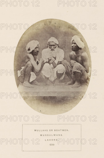Portrait of three unknown bargemen from Lahore, Punjab, Pakistan, photograph, page, inscription: 'MULLAHS OR BOATMEN., MUSSULMANS., LAHORE.', number: '(239)', Lahore, c. 1862 - in or before 1872, photographer, paper, albumen print, height 128 mm x width 104 mm, human races, peoples, nationalities, A sepia-toned oval photograph shows three barefoot men seated close together on a raised surface, each wearing light cloths wrapped around their heads and simple lower garments; the central man has a full beard and is looking downward while holding something with both hands, the two men on either side are crouched facing inward with visible lean torsos and folded arms, and the background is plain and slightly mottled.