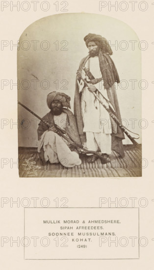 Portrait of two men with muskets from the Sepah Afridi tribe of Kohat, Khyber Pakhtunkhwa, Pakistan, photograph, page, inscription: 'MULLIK MORAD & AHMEDSHERE., SIPAH AFREEDEES., SOONNEE MUSSULMANS., KOHAT.', number: '(249)', Kohat, 1861, photographer, paper, albumen print, height 115 mm x width 87 mm, firearms: rifle, human races, peoples, nationalities, A sepia-toned photograph shows two men wearing turbans and loose traditional clothing; one man is seated on a striped rug holding a long rifle across his lap, and the other man stands beside him holding a long firearm and wearing a draped shawl over his shoulders.