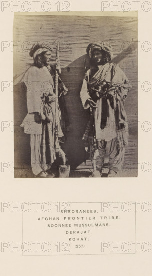 Portrait of two unknown men with masks from the Sherani tribe of Kohat, Khyber Pakhtunkhwa, Pakistan, photograph, page, inscription: 'SHEORANEES., AFGHAN FRONTIER TRIBE., SOONNEE MUSSULMANS., DERAJAT., KOHAT.', number: '(257)', Kohat, c. 1862 - in or before 1872, photographer, paper, albumen print, height 114 mm x width 85 mm, head-gear: turban, firearms: rifle, human races, peoples, nationalities, A sepia-toned photograph shows two standing men facing each other against a plain backdrop. Both wear layered loose garments with draped fabric and turbans on their heads. Each man holds a long, vertical object that reaches near the top of the image. The man on the left stands with his body turned slightly toward the other, one hand resting near his waist and the other gripping his object, and he has visible long hair beneath his turban. The man on the right stands with a relaxed posture, one arm bent and resting across his torso while the other hand holds his object; he has a beard and his ...