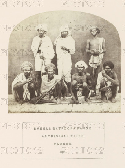Portrait of a group of people from the Bhil tribe of the Satpura mountains, Sagar, Madhya Pradesh, India, photograph, page, number: '364.', inscription: 'BHEELS SATPOORA RANGE., ABORIGINAL TRIBE., SAUGOR.', photographer: James John Waterhouse (possibly), 1862, Central India, paper, albumen print, height 97 mm x width 107 mm, human races, peoples, nationalities, A sepia-toned photograph shows a group of seven men arranged in two rows against a plain backdrop, with three standing in the back and four seated or squatting in the front on a raised narrow platform; the men wear varied headwraps and cloth draped around their bodies, some covering shoulders and torsos while others are bare-chested, and several hold long wooden staffs or sticks; facial hair varies among them, and their expressions are neutral; the image is bordered by a rounded arch at the top and has a blank area beneath the photograph.