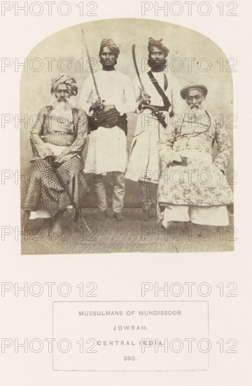 Portrait of four unknown Islamic men from Jaora, Madhya Pradesh, India, photograph, page, inscription: 'MUSSULMANS OF MUNDISOOR., JOWRAH., CENTRAL INDIA.', number: '380.', photographer: James John Waterhouse (possibly), Jaora, 1862, Central India, paper, albumen print, height 116 mm x width 106 mm, firearms: rifle, human races, peoples, nationalities, A faded black-and-white photograph shows four men posed in two seated and two standing positions within a rounded-top frame; the seated men wear patterned garments and turbans and hold long staffs or canes while the standing men wear plain tunics with sashes and turbans and hold curved blades and a long straight pole, all four displaying neutral facial expressions and facial hair, with a plain backdrop and a patterned floor beneath them.