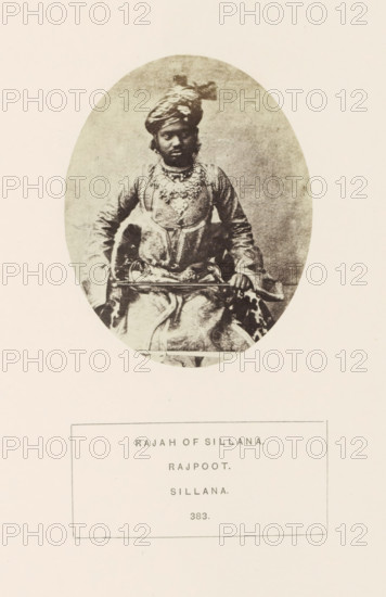 Portrait of Dudai Singh, the Raja of Sailana, Madhya Pradesh, India, photograph, page, number: '383.', inscription: 'RAJAH OF SILLANA., RAJPOOT., SILLANA.', photographer: James John Waterhouse, Sailana, 1862, Central India, paper, albumen print, height 95 mm x width 75 mm, ruler, sovereign, human races, peoples, nationalities, An oval-framed sepia photograph of a seated person wearing a patterned turban and ornate layered clothing, including a decorated upper garment and a draped lower garment, with visible necklaces and jewelry; the person sits with one hand resting on a horizontal object and the other near their lap, against a plain textured background and surrounded by a light border on a blank page.