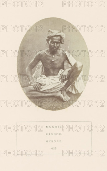 Portrait of an unknown man from the Mochi community (cobbler) of Mysore, Karnataka, India, photograph, page, number: '423.', inscription: 'MOCHIS., HINDOO., MYSORE.', Mysore, c. 1865 - in or before 1875, photographer, South India, paper, albumen print, height 97 mm x width 76 mm, human races, peoples, nationalities, An oval sepia photograph shows a seated man with a turban and a draped cloth around his lower body, his upper body bare and a small pendant visible at his chest; he sits with one knee raised and one arm resting on his knee while the other hand touches the cloth, his facial expression is neutral and his gaze is toward the camera, and the background within the oval is plain and unadorned.