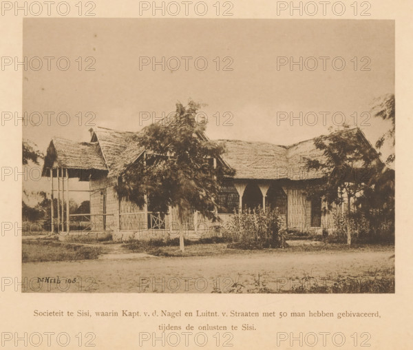View of a society in Sisi, Society in Sisi, in which Capt. vd Nagel and Luitnt. v. Streets with 50 men bivacated during the unrest in Sisi, page, photomechanical print, maker: Christiaan Johan Neeb, c. 1892 - in or before 1897, paper, collotype, photoprint, height 122 mm x width 166 mm, landscape with ruins, Indonesia, A sepia-toned photograph shows a single-story building with a thatched roof and woven walls, partially obscured by leafy trees and shrubs in front; the structure features open archways and a small porch area with vertical supports, and there is a grassy area and a dirt path in the foreground.
